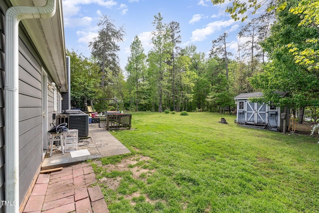 view of yard featuring cooling unit, a storage unit, a patio, and an outdoor structure