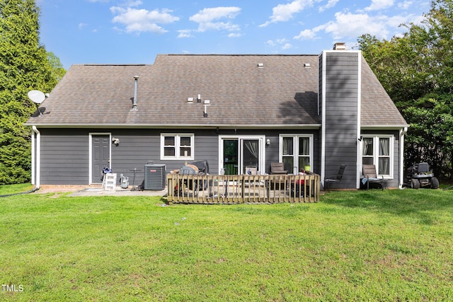 rear view of house featuring a patio, a chimney, a yard, and central AC unit