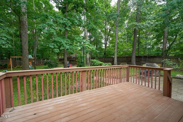 deck featuring a fenced backyard and a playground