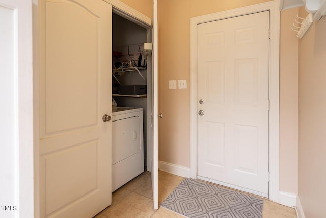 interior space with light tile patterned floors, baseboards, and washer / clothes dryer