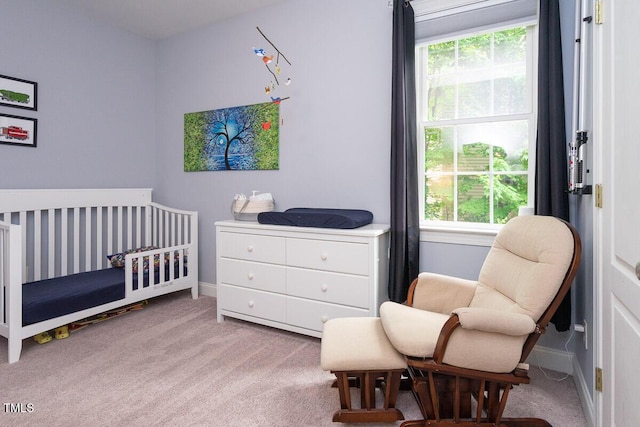 carpeted bedroom with multiple windows, a nursery area, and baseboards