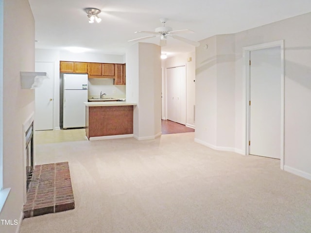 403 Gooseneck Dr Unit A-1, Cary, NC 27513 - kitchen with freestanding refrigerator, brown cabinets, light carpet, a sink, and a ceiling fan
