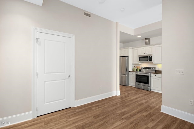 kitchen with visible vents, baseboards, appliances with stainless steel finishes, and white cabinets