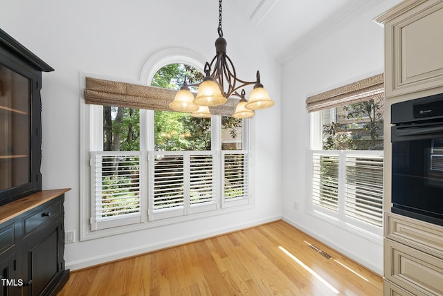 unfurnished dining area with a chandelier, baseboards, vaulted ceiling, and visible vents