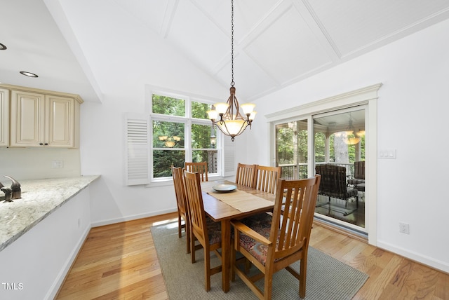 dining room featuring an inviting chandelier, plenty of natural light, light wood finished floors, and beam ceiling