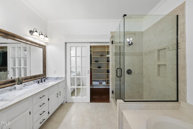 bathroom with a sink, a spacious closet, a shower stall, and ornamental molding