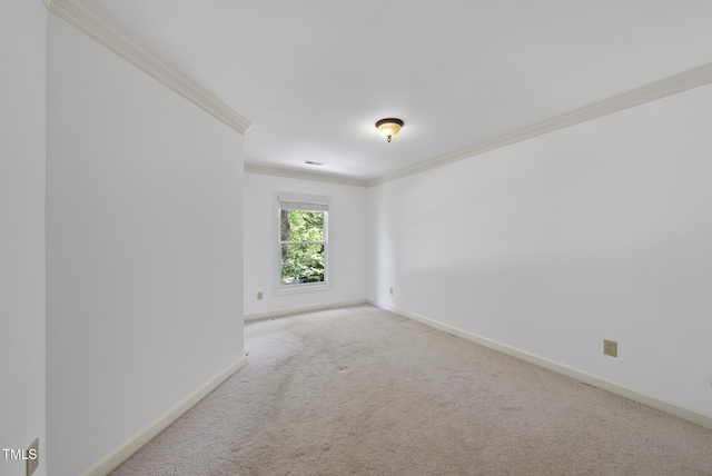 empty room featuring carpet floors, ornamental molding, and baseboards