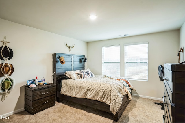 bedroom with visible vents, light carpet, and baseboards