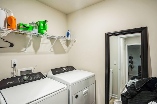 washroom featuring baseboards, wood finished floors, laundry area, and independent washer and dryer