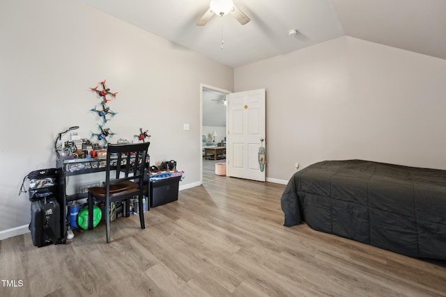 bedroom featuring a ceiling fan, baseboards, vaulted ceiling, and wood finished floors