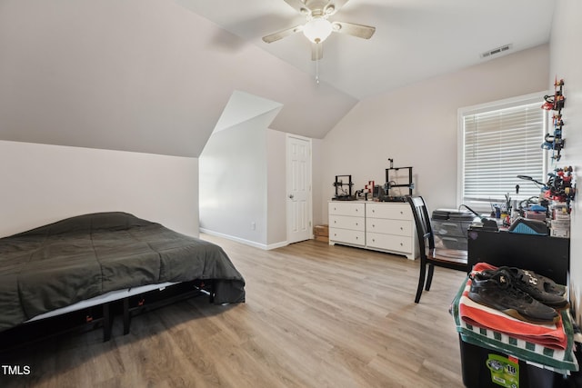 bedroom featuring light wood finished floors, a ceiling fan, baseboards, lofted ceiling, and visible vents