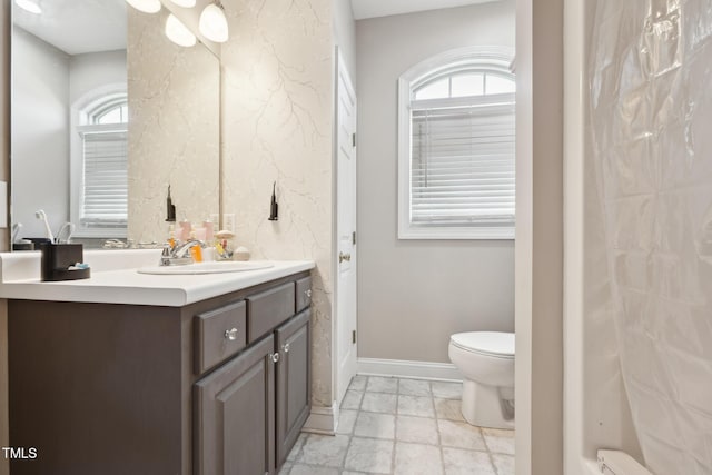 full bath with toilet, baseboards, and vanity