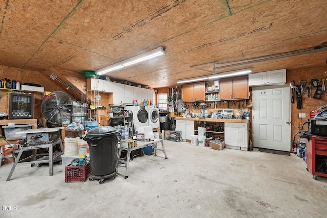 garage featuring washing machine and dryer and a workshop area