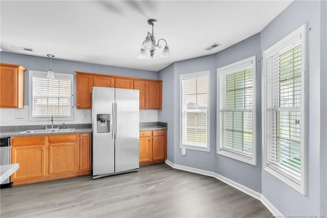 1948 Yellowbrick Rd, Fayetteville, NC 28314 - kitchen with appliances with stainless steel finishes, a chandelier, light wood finished floors, and pendant lighting