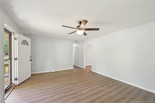 spare room with ceiling fan, baseboards, and wood finished floors