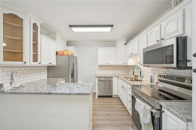 kitchen featuring white cabinets, tasteful backsplash, appliances with stainless steel finishes, and a sink