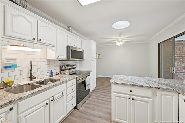 kitchen featuring stainless steel appliances, a sink, light wood-type flooring, crown molding, and tasteful backsplash