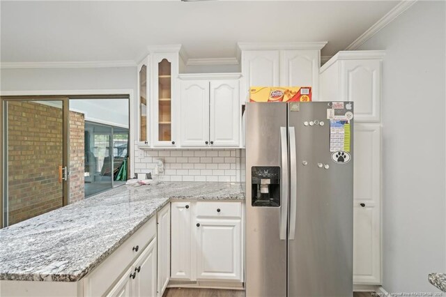 kitchen featuring stainless steel fridge, glass insert cabinets, and white cabinetry