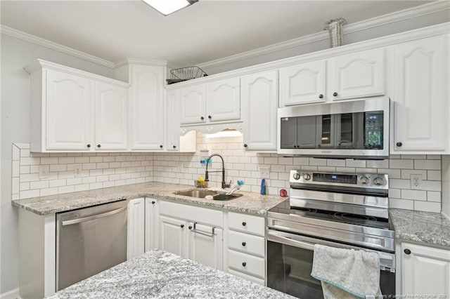 kitchen featuring light stone counters, appliances with stainless steel finishes, white cabinetry, and a sink