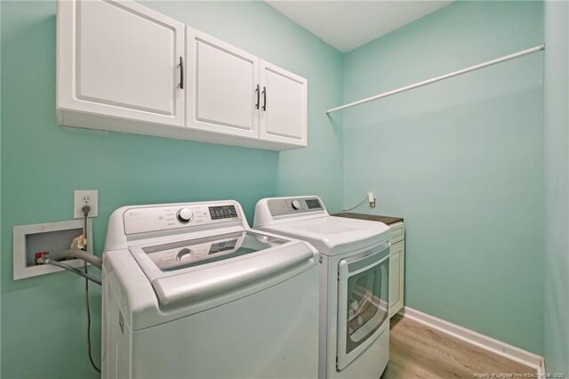 laundry area with cabinet space, independent washer and dryer, light wood-style flooring, and baseboards