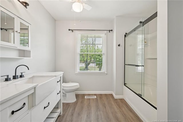 full bath with ceiling fan, vanity, wood finished floors, and plenty of natural light