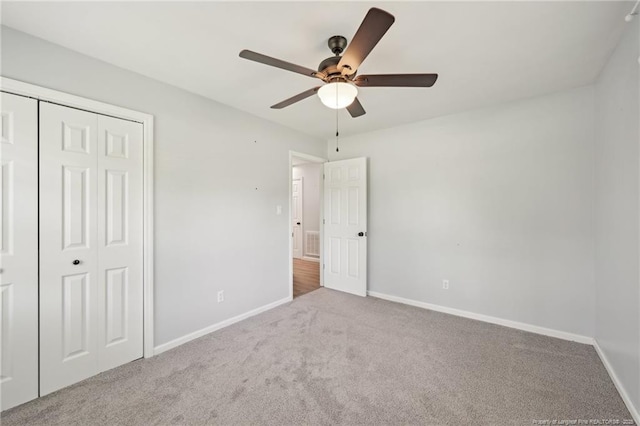 unfurnished bedroom featuring a ceiling fan, baseboards, carpet floors, and a closet