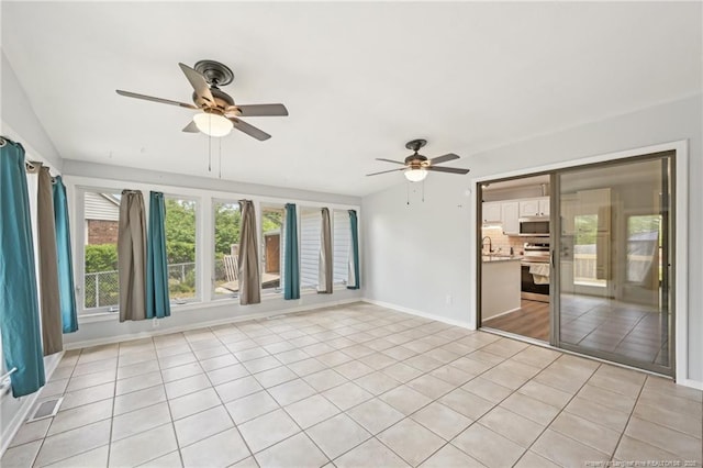 interior space with baseboards, a ceiling fan, visible vents, and light tile patterned flooring