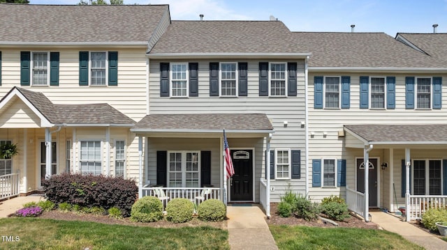multi unit property with roof with shingles and covered porch
