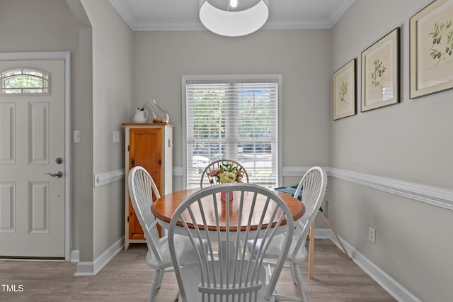 dining room with ornamental molding, light wood-style flooring, and a wealth of natural light