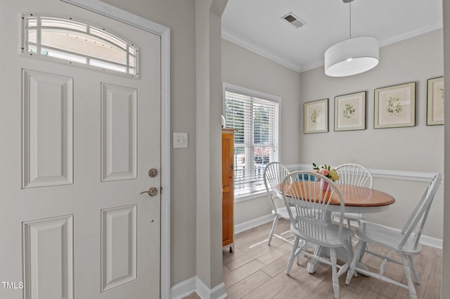 foyer with visible vents, ornamental molding, baseboards, and light wood-style floors
