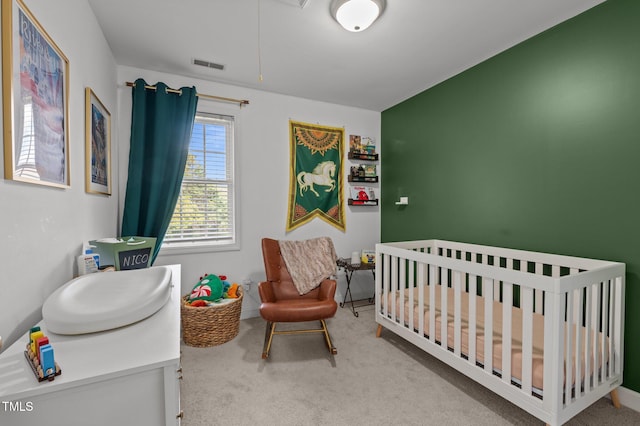 carpeted bedroom with a nursery area and visible vents