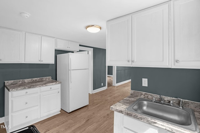 1219 Junction Rd, Durham, NC 27704 - kitchen featuring freestanding refrigerator, light wood-style floors, and white cabinets