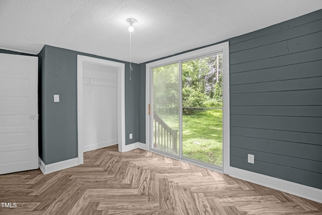 1219 Junction Rd, Durham, NC 27704 - unfurnished bedroom with a closet, access to outside, a textured ceiling, and wood walls