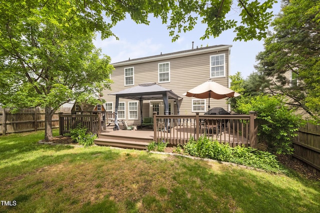 back of house featuring a lawn, a deck, a gazebo, and a fenced backyard