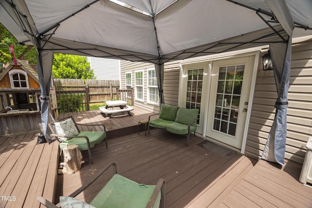 deck with fence, french doors, and an outdoor living space