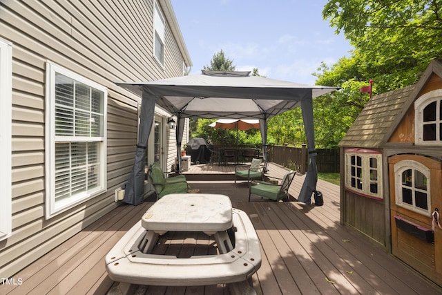 wooden deck with a gazebo and outdoor dining space