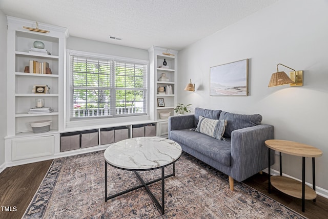 living room with visible vents, a textured ceiling, dark wood finished floors, and baseboards