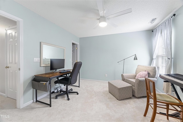 office with a ceiling fan, a textured ceiling, light colored carpet, visible vents, and baseboards