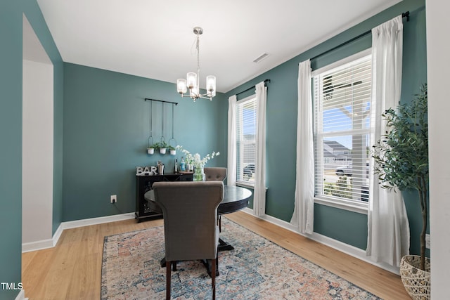 303 Forestview Crest Way, Fuquay Varina, NC 27526 - dining room with baseboards, an inviting chandelier, a healthy amount of sunlight, and wood finished floors