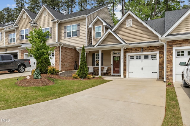 106 Churment Ct, Durham, NC 27703 - multi unit property with a shingled roof, a front lawn, concrete driveway, a porch, and stone siding