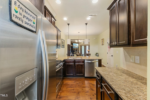 106 Churment Ct, Durham, NC 27703 - kitchen featuring dark wood finished floors, appliances with stainless steel finishes, dark brown cabinets, and light stone countertops