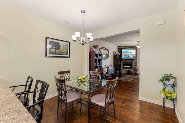 106 Churment Ct, Durham, NC 27703 - dining area featuring ceiling fan with notable chandelier, baseboards, a stone fireplace, and wood finished floors