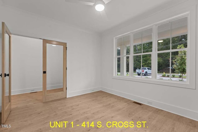 unfurnished room with visible vents, a ceiling fan, baseboards, and light wood finished floors