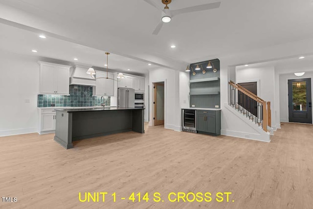 kitchen with a sink, white cabinetry, ceiling fan, and tasteful backsplash