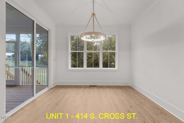 unfurnished dining area with an inviting chandelier, baseboards, and wood finished floors