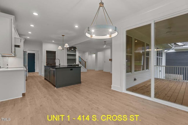 kitchen with decorative light fixtures, a notable chandelier, light wood-style floors, recessed lighting, and white cabinetry