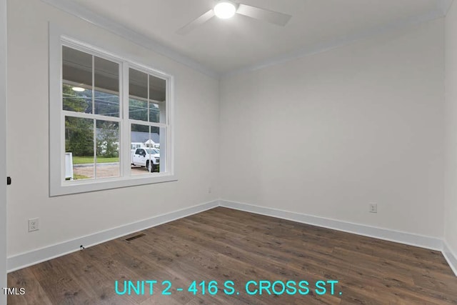 unfurnished room featuring visible vents, crown molding, baseboards, ceiling fan, and dark wood-style floors