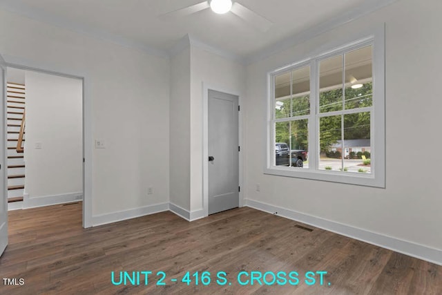 unfurnished bedroom with ceiling fan, visible vents, wood finished floors, baseboards, and ornamental molding