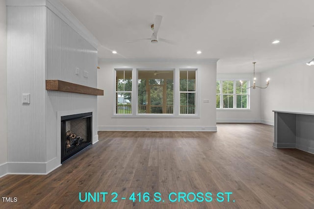 unfurnished living room featuring baseboards, a fireplace, ceiling fan with notable chandelier, and wood finished floors