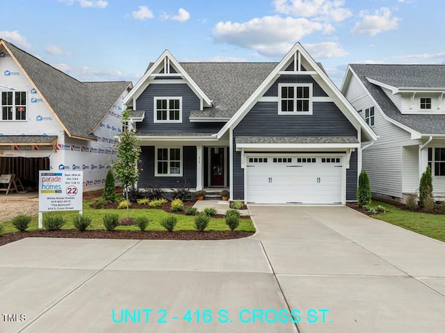 view of front of house with a shingled roof and driveway